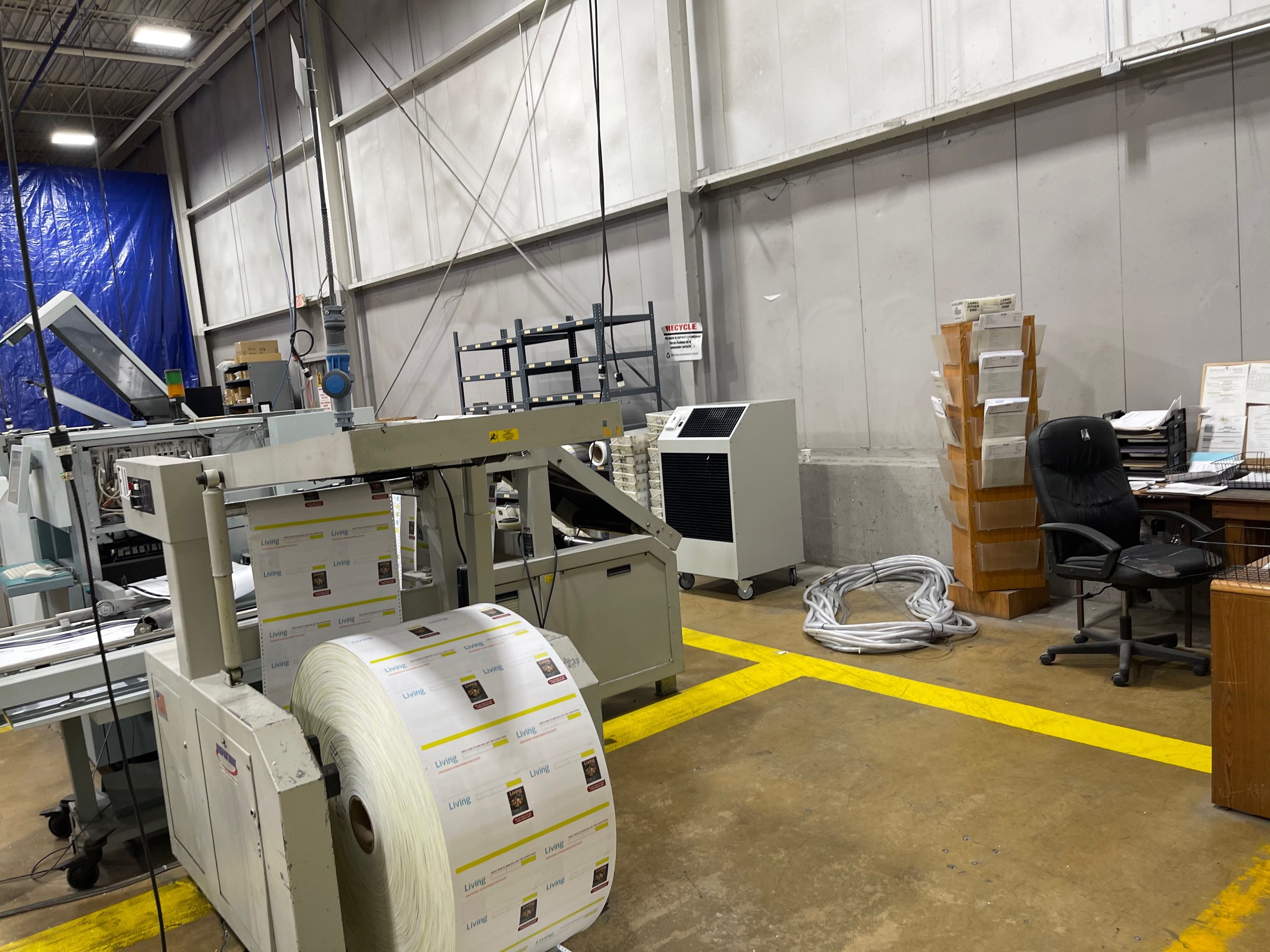 A manufacturing printing machine area, which is quarantined off with tarps to trap the cooling output from temporary spot cooler units. 